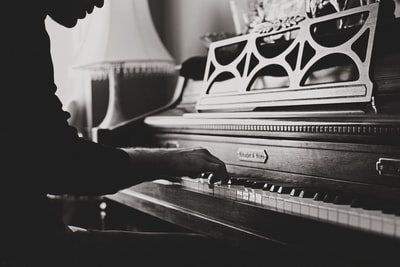 灰阶照片的男子演奏斯皮尼特钢琴特写照片